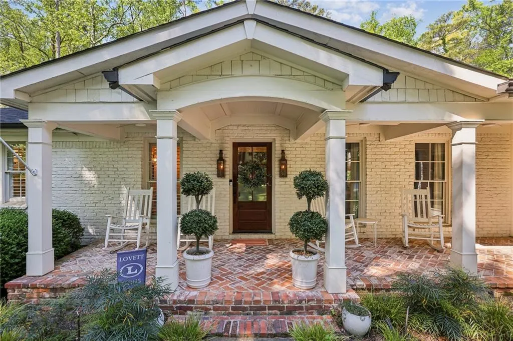 View of exterior entry featuring a porch and brick siding