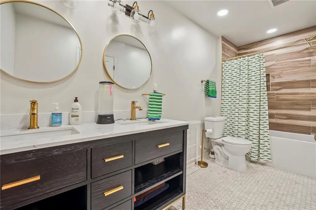 Full bath featuring double vanity, recessed lighting, shower / tub combo, and light tile patterned floors