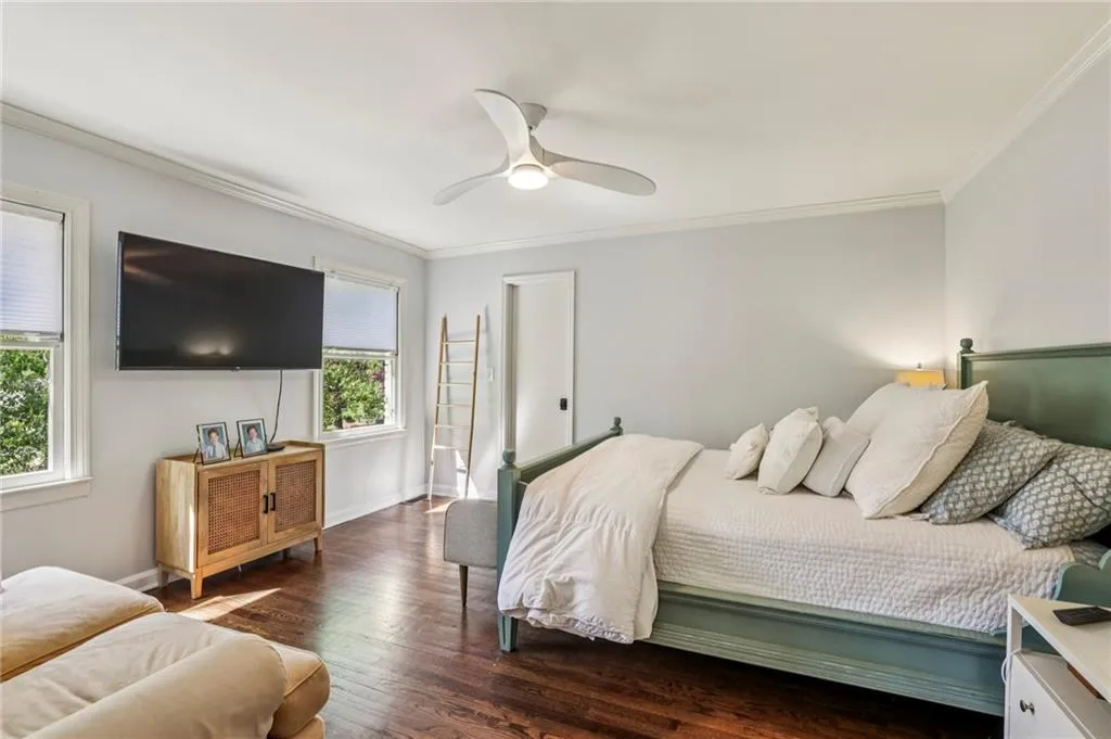 Bedroom featuring crown molding, dark wood-type flooring, and ceiling fan