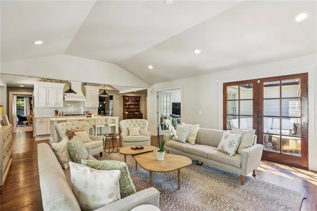 Living room featuring dark wood-style floors, french doors, recessed lighting, and vaulted ceiling