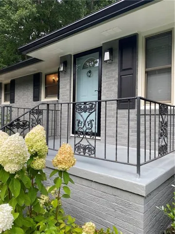 Entrance to property with brick siding and covered porch