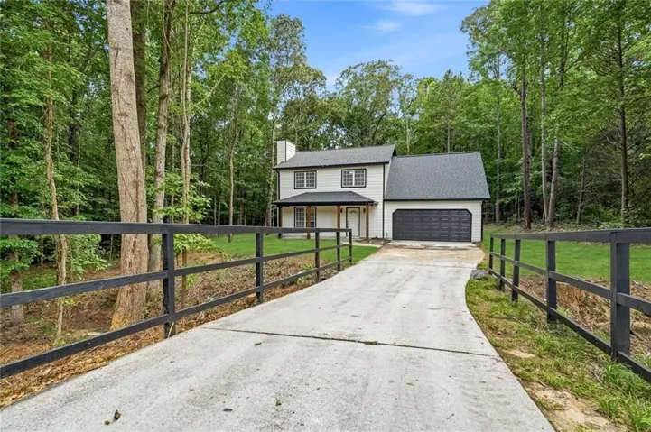 Two-story residence with a two-car garage, black framed windows, and a covered porch entry