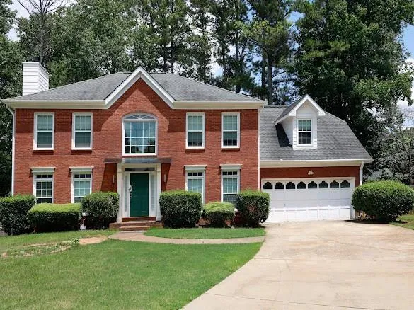Brick exterior residence featuring a prominent arched window and white trim