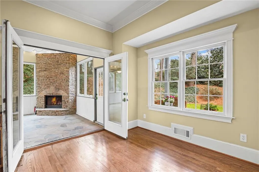 Entryway with crown molding, a stone fireplace, and wood finished floors