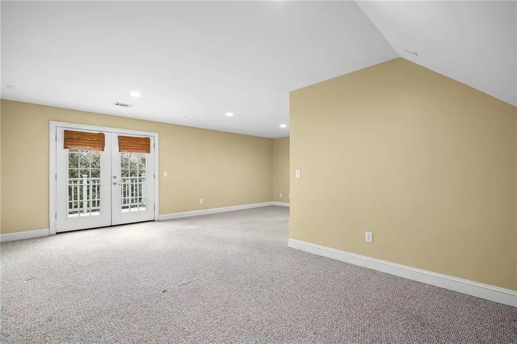 Empty room featuring french doors, carpet, and recessed lighting
