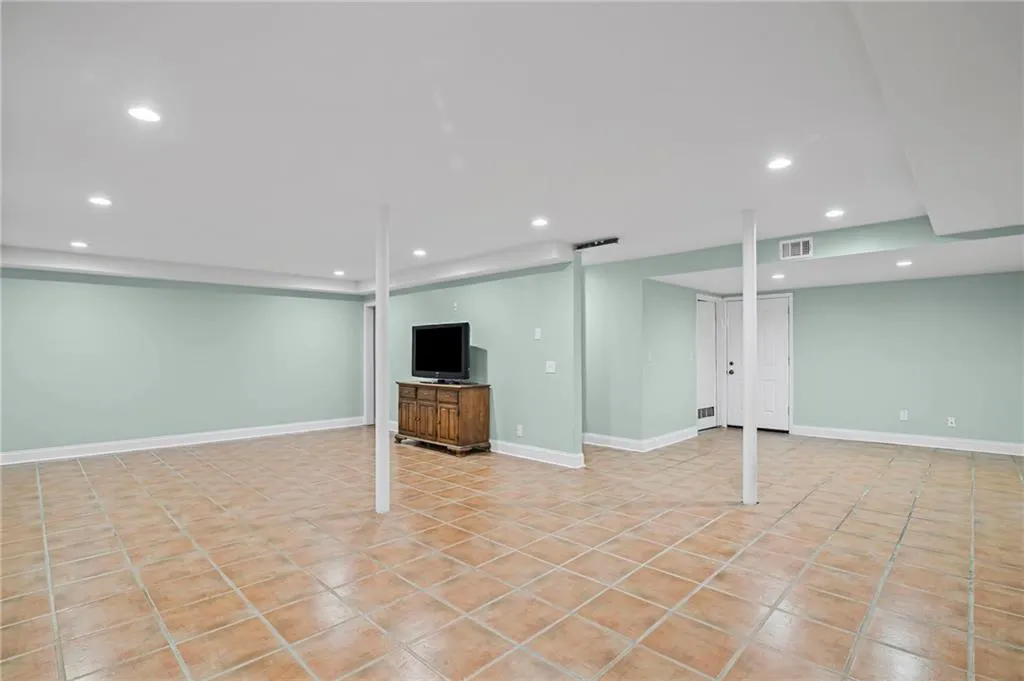 Finished basement featuring recessed lighting and light tile patterned floors
