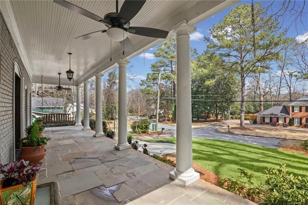 Porch with a ceiling fan and a lawn