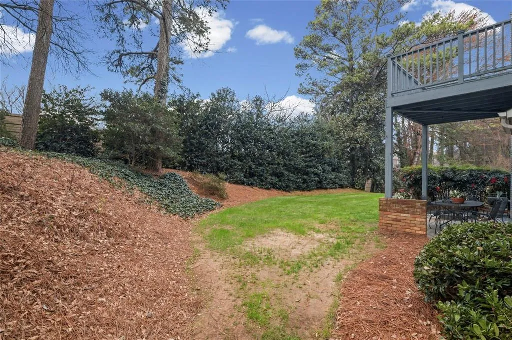 View of grassy yard with a wooden deck