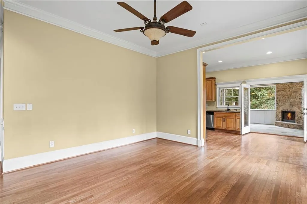 Unfurnished living room with a brick fireplace, light wood-style flooring, ornamental molding, ceiling fan, and recessed lighting