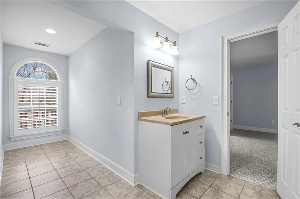 Bathroom featuring vanity, light tile patterned flooring, and light carpet