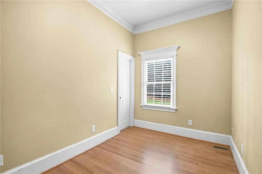 Empty room featuring ornamental molding and light wood-style floors