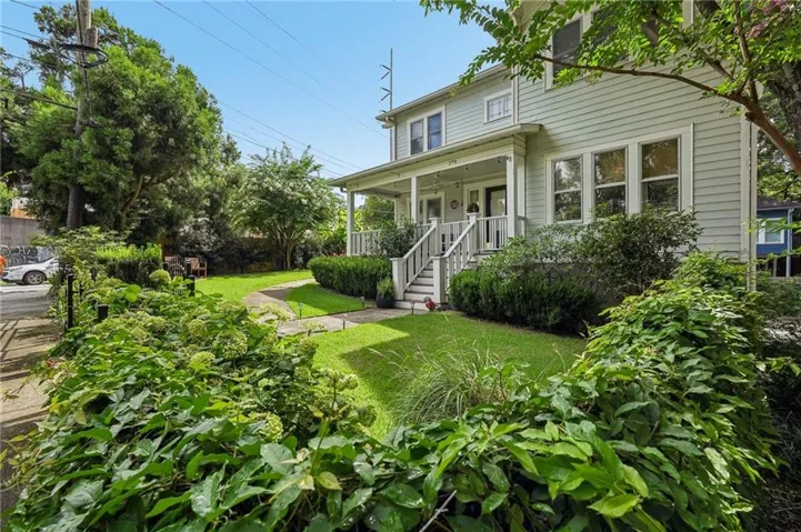 Two-story residence with light-colored siding, a covered porch, and white railings