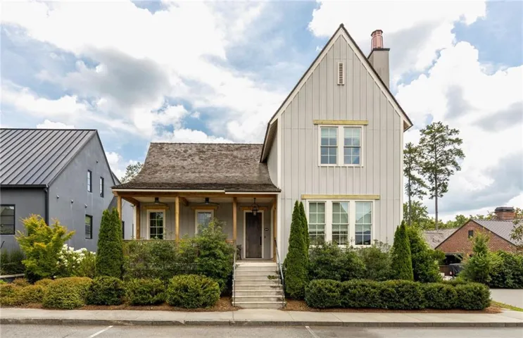 Gable-style home with board and batten siding, a covered porch, and a shingle roof