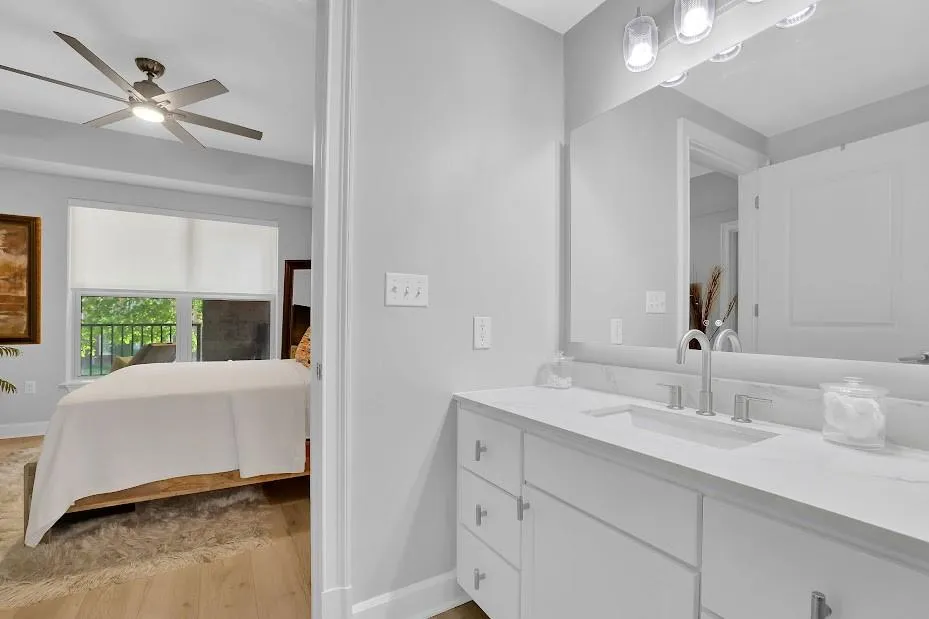 Bathroom with wood-type flooring, vanity with extensive cabinet space, and ceiling fan