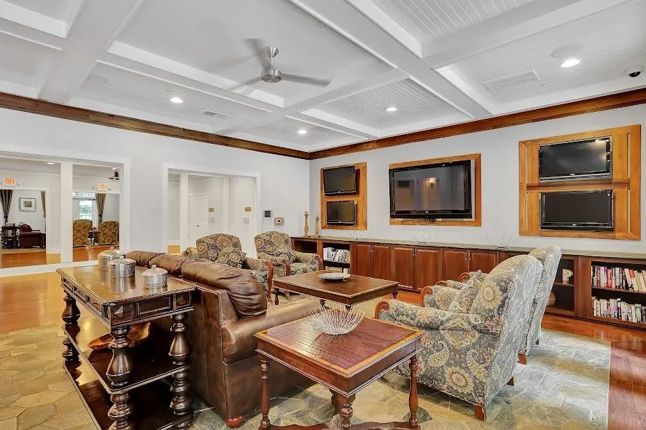 Living room featuring coffered ceiling, ceiling fan, light hardwood / wood-style flooring, and beamed ceiling