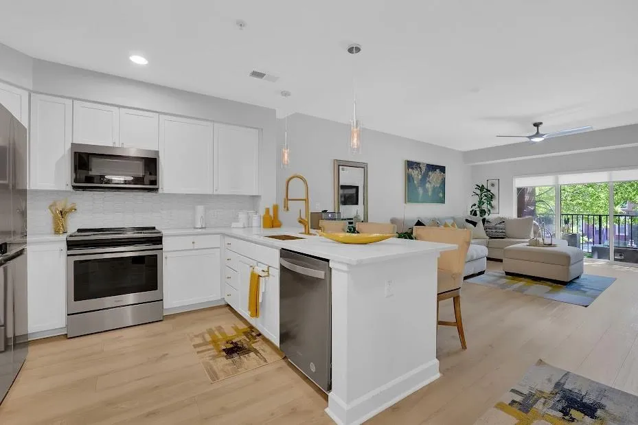 Kitchen with stainless steel appliances, ceiling fan, sink, light wood-type flooring, and decorative light fixtures