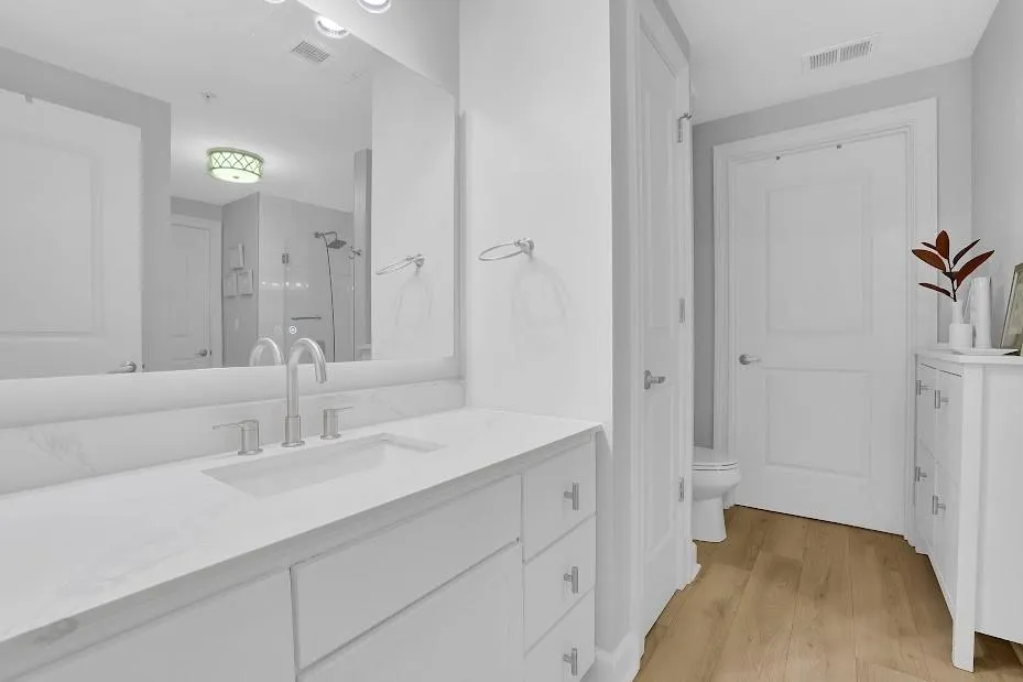 Bathroom featuring hardwood / wood-style floors, toilet, and vanity
