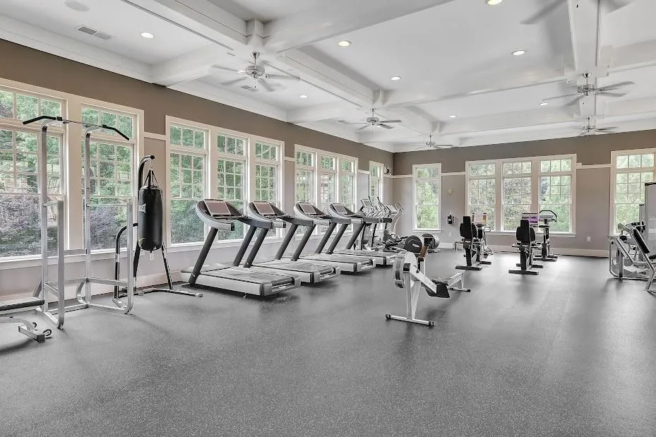 Exercise room with coffered ceiling, a healthy amount of sunlight, and ceiling fan