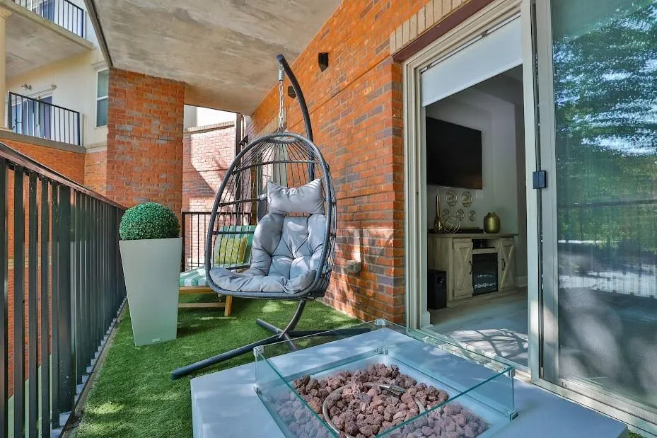 View of patio with a balcony and a fire pit