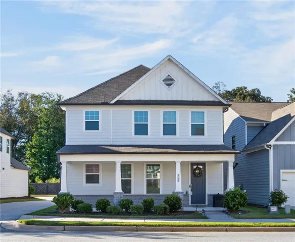 Two-story residence with light gray siding, a covered front porch with white columns, and a dark gray entry door