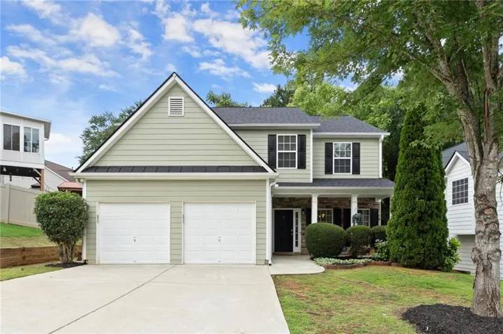 Two-story residence featuring light green siding and black shutters