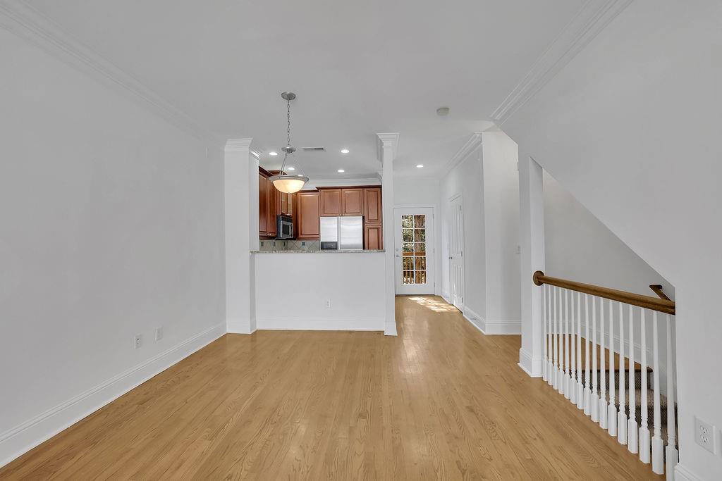 Unfurnished living room featuring light hardwood / wood-style flooring and ornamental molding