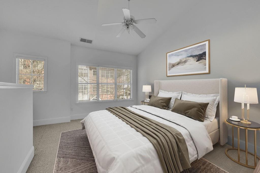 Bedroom with light carpet, ceiling fan, and vaulted ceiling