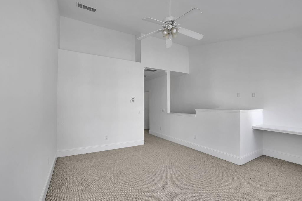 Carpeted spare room with ceiling fan