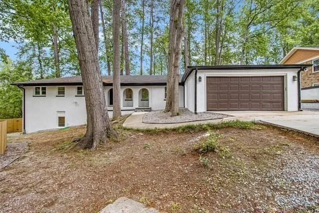 View of front of house featuring stucco siding, a garage, and concrete driveway