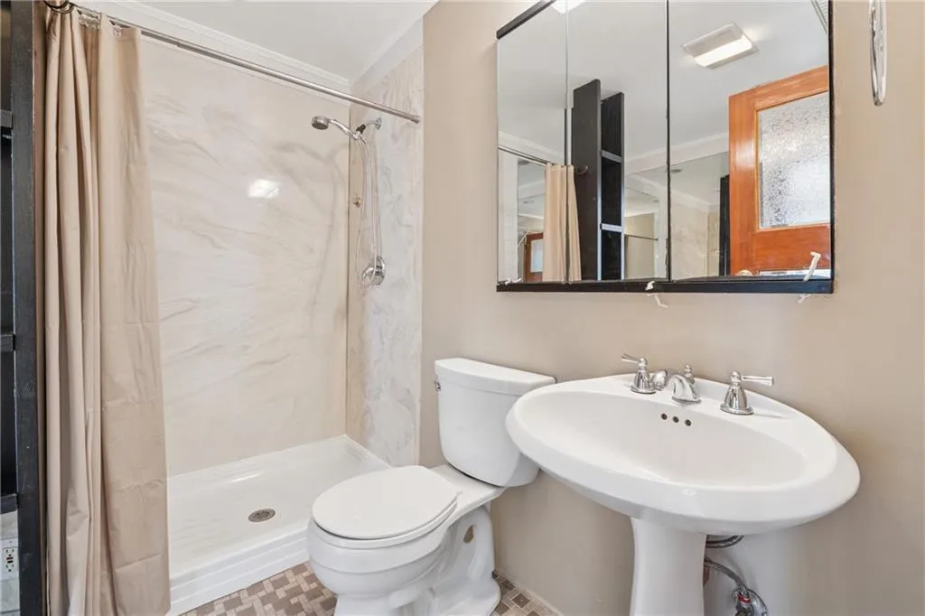 Full bathroom featuring a shower with curtain and toilet