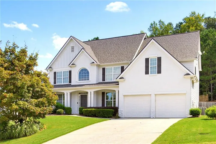 Two-story residence with white siding, a covered front porch, and a two-car garage