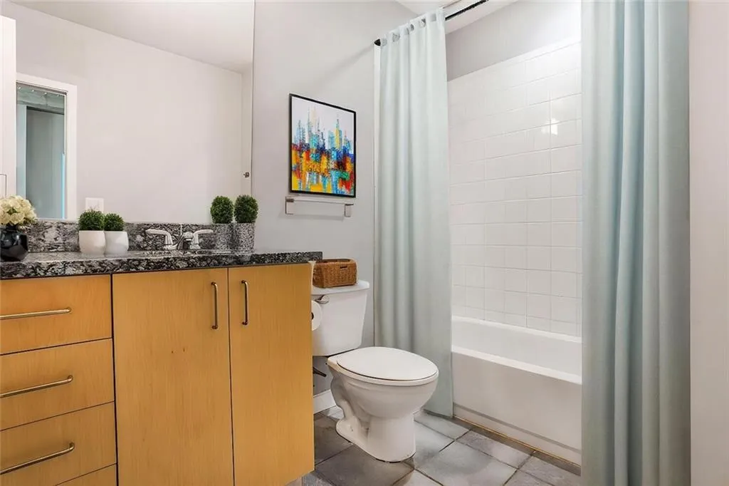 Bathroom featuring shower / tub combo with curtain, toilet, tile patterned flooring, and vanity