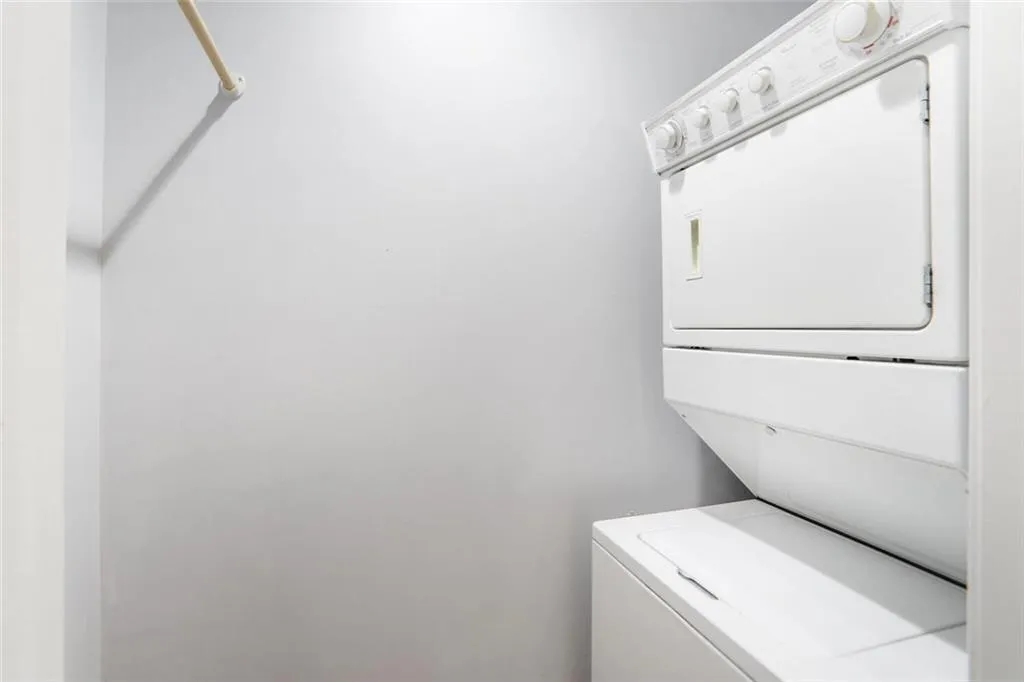 Clothes washing area featuring stacked washer / drying machine and laundry area
