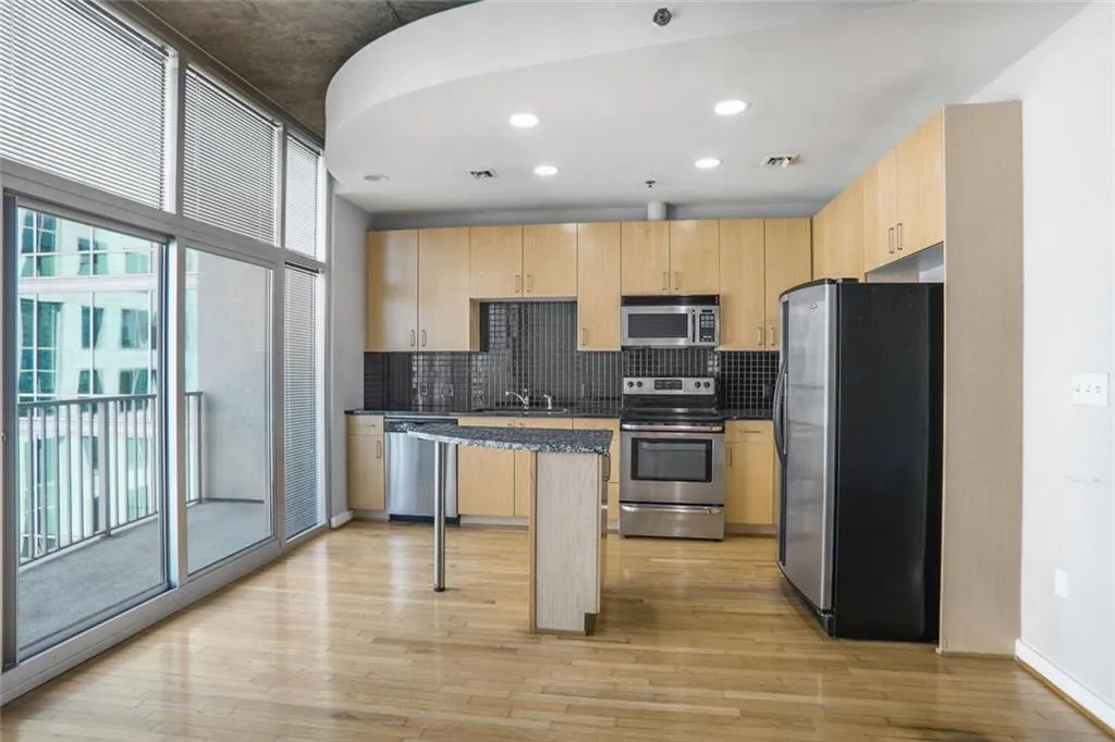 Kitchen with light brown cabinets, light wood-style flooring, and appliances with stainless steel finishes