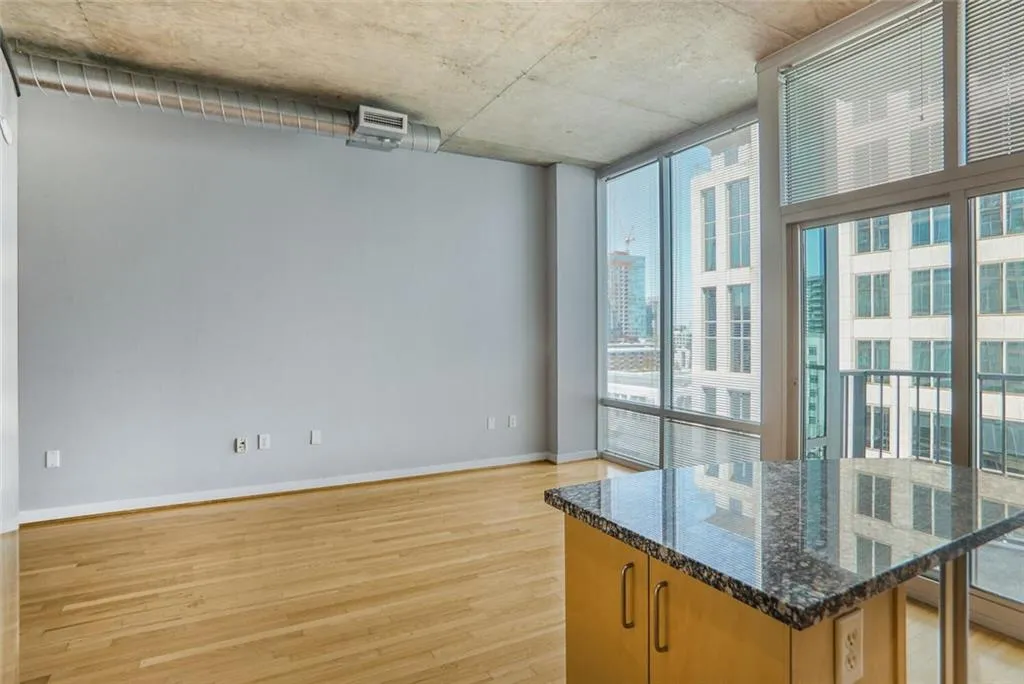 Spare room featuring light wood-style flooring, baseboards, expansive windows, and a wealth of natural light