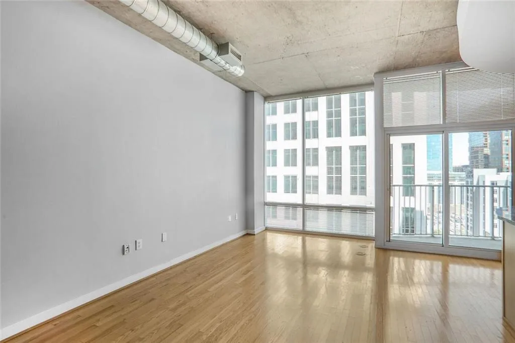 Unfurnished room with baseboards, floor to ceiling windows, and wood finished floors