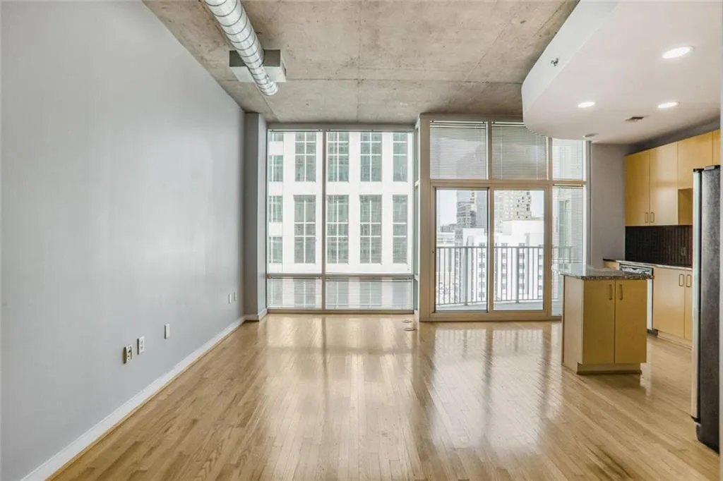Unfurnished living room featuring baseboards, expansive windows, and light wood-style flooring