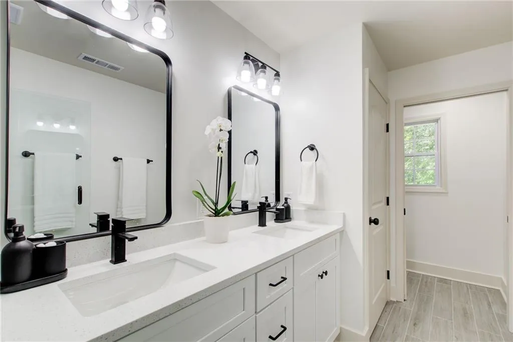 Bathroom featuring  a double vanity and beautiful cabinetry. Water closet in it's own separate room with a window