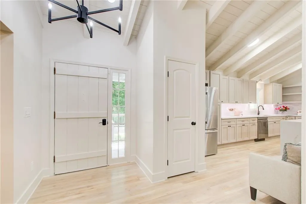 Foyer featuring a chandelier, beam ceiling, hard wood flooring and vaulted ceiling
