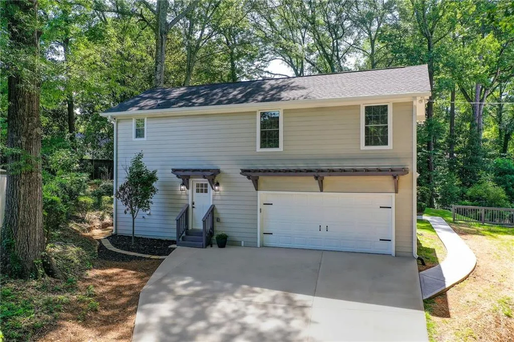 Traditional home with a garage, driveway, and entry steps
