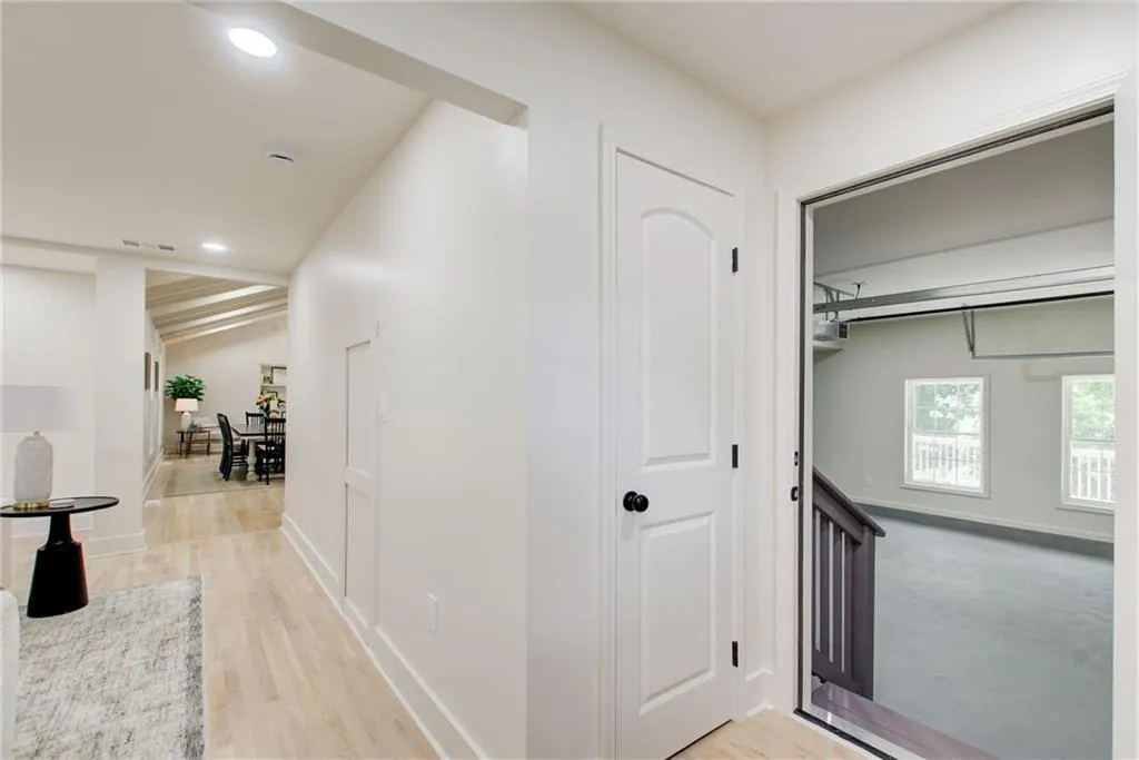 Hallway featuring light wood finished floors, recessed lighting, and vaulted ceiling