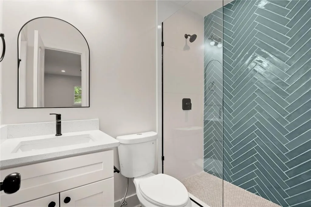 Hall bathroom featuring vanity and tiled shower