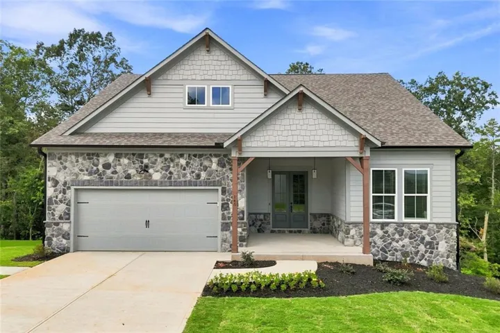 View of front of home with roof with shingles, sto