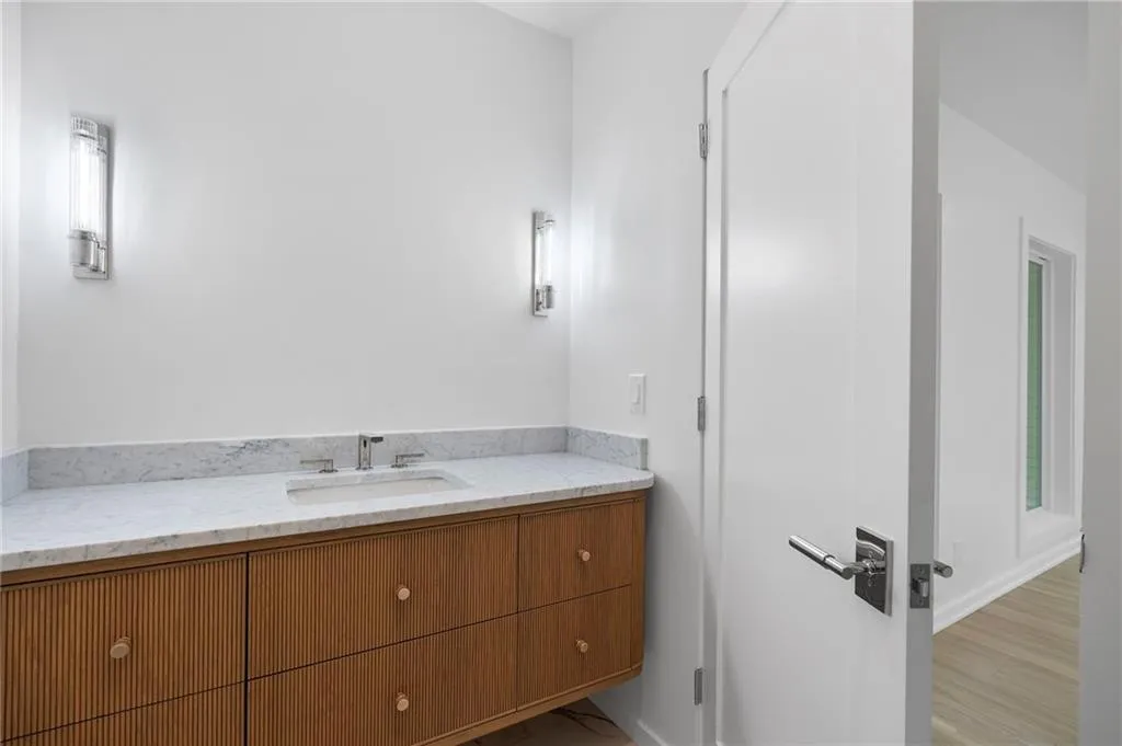 White vanity with a light-colored countertop and integrated sink