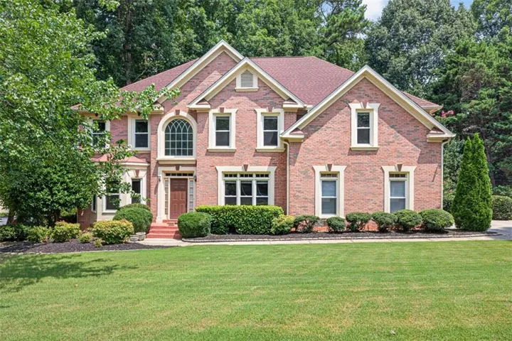 Brick exterior with white trim details and a red roof