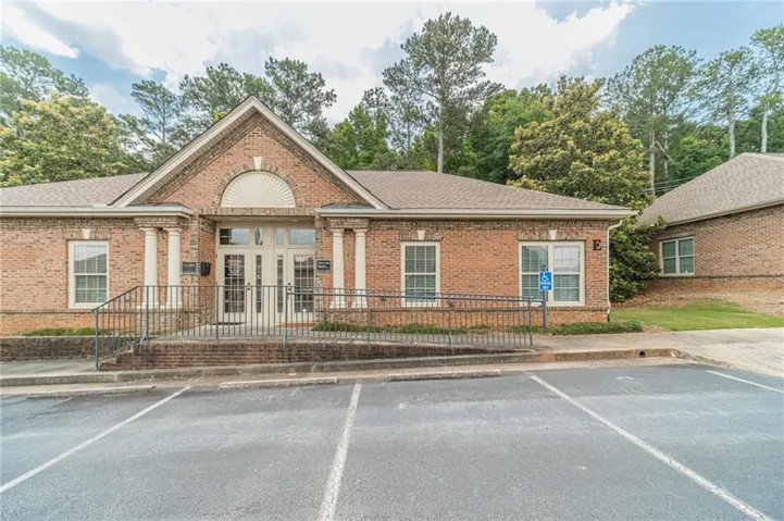 Brick-front building featuring a central arched entryway and white columns