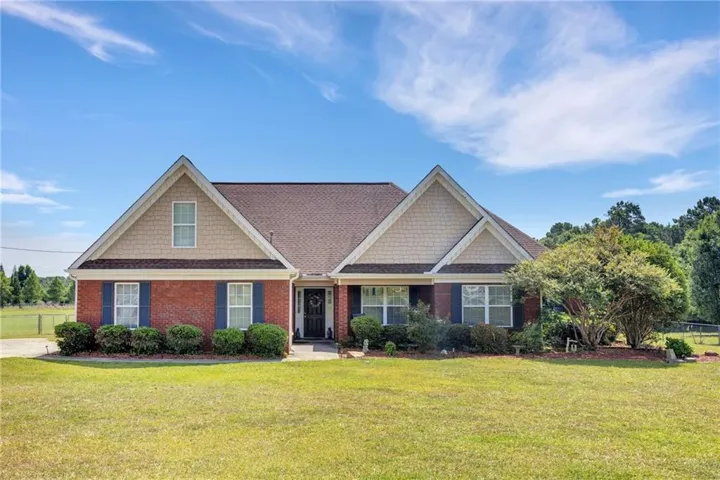 Traditional brick home with a gabled roofline and shake siding accents