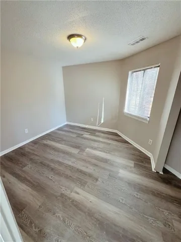 Unfurnished room featuring light wood-style floors and a textured ceiling