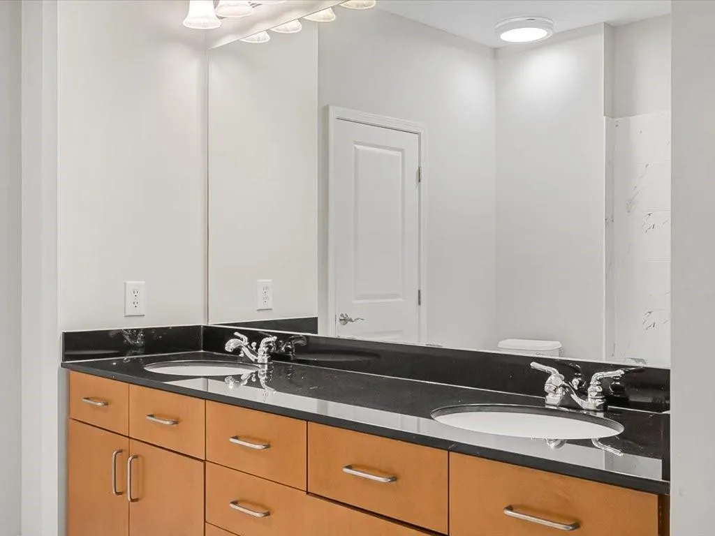 Full bathroom featuring double vanity and toilet