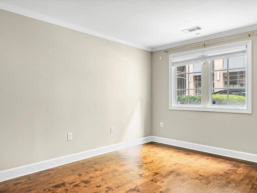 Spare room with wood finished floors and ornamental molding
